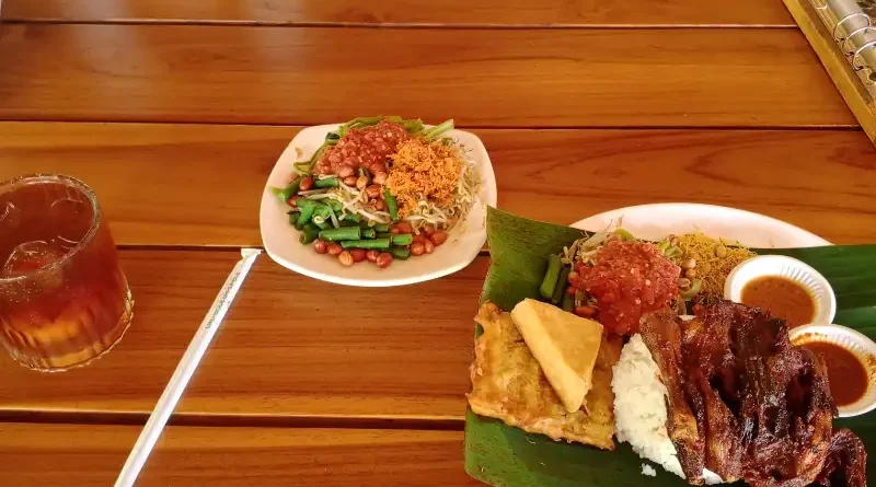Ilustrasi sajian ayam bakar bumbu rempah dan sate daging khas daerah di atas piring tradisional.