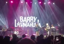 Gitar bass elektrik profesional di atas panggung jazz dengan pencahayaan hangat sebagai simbol karier Barry Likumahuwa.