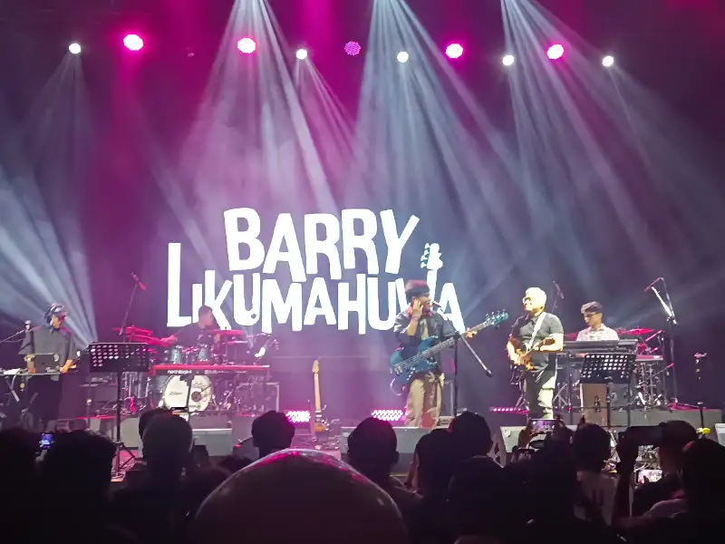 Gitar bass elektrik profesional di atas panggung jazz dengan pencahayaan hangat sebagai simbol karier Barry Likumahuwa.