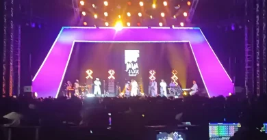 Gitar elektrik klasik di atas panggung dengan pencahayaan warna-warni nuansa disko dan funk.