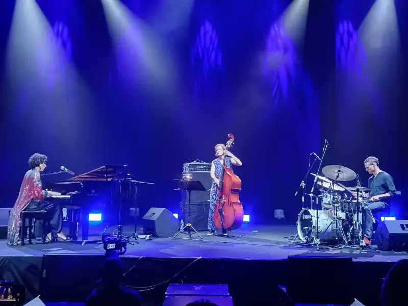 Ilustrasi panggung jazz dengan instrumen piano dan kontrabas dalam pencahayaan estetis.