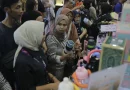 Deretan botol minum tumbler estetik berwarna-warni yang disusun rapi di rak pameran.