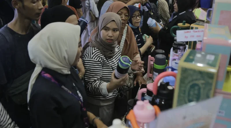 Deretan botol minum tumbler estetik berwarna-warni yang disusun rapi di rak pameran.