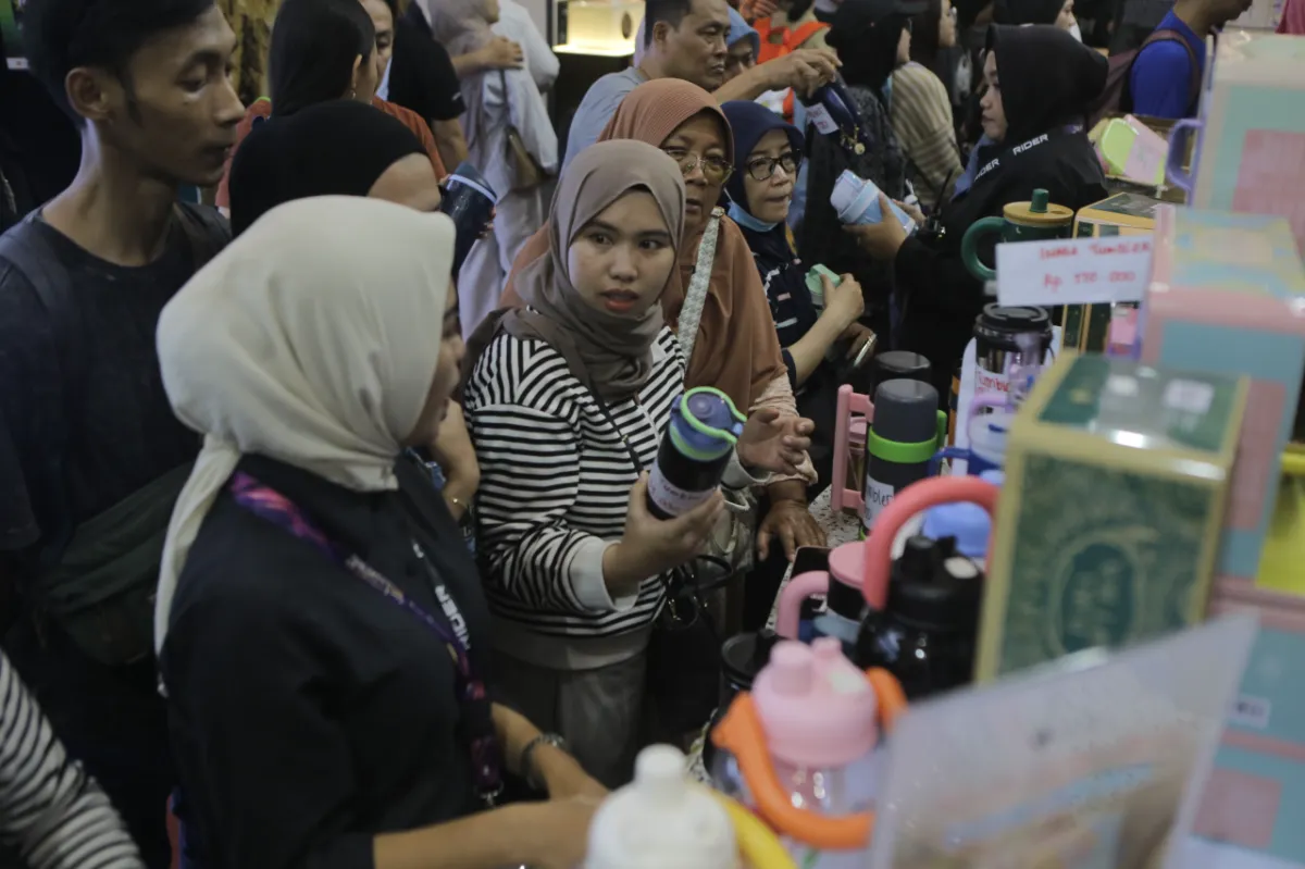 Deretan botol minum tumbler estetik berwarna-warni yang disusun rapi di rak pameran.