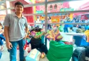 Ilustrasi tumpukan tas belanja dan koper di area gedung pameran yang modern.