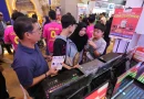 Ilustrasi deretan laptop modern dengan penawaran promo diskon di pameran elektronik.