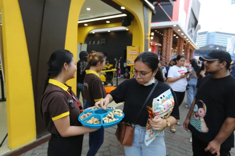 Ilustrasi stan pameran dengan sampel camilan dan minuman gratis di acara Jakarta Fair 2026.