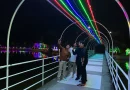 Pemandangan instalasi lampu warna-warni di area danau pada malam hari.