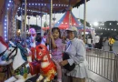Wahana komidi putar warna-warni berputar indah di sebuah taman bermain malam hari