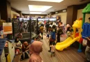Tumpukan mainan anak berwarna-warni yang tertata rapi di rak toko mainan pameran