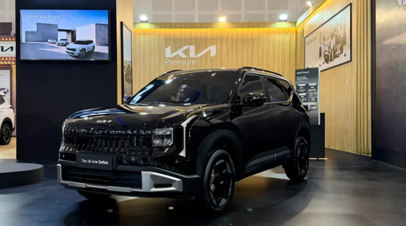 Logo Kia perak berkilau yang elegan melambangkan penawaran istimewa dan program garansi jangka panjang