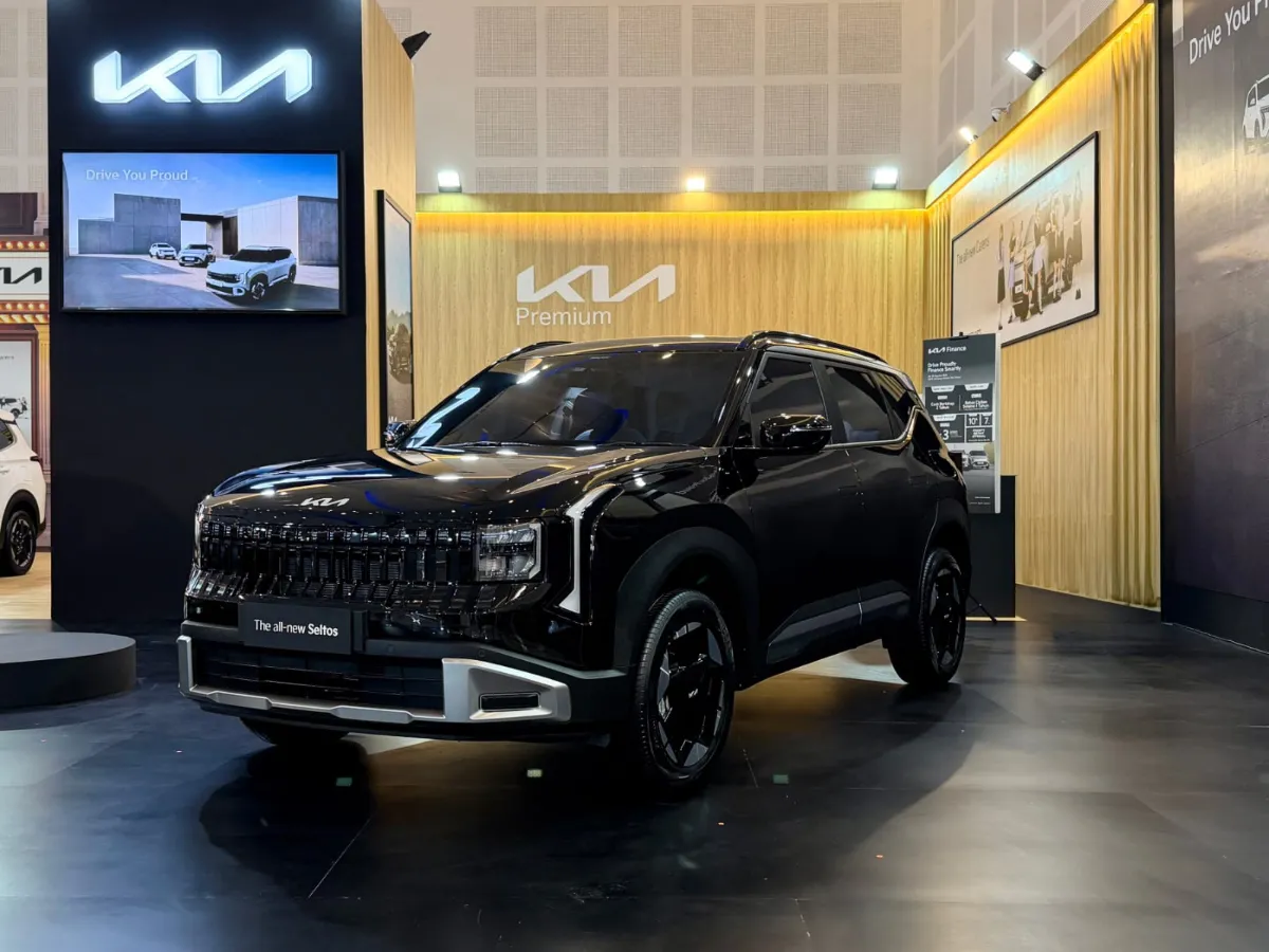 Logo Kia perak berkilau yang elegan melambangkan penawaran istimewa dan program garansi jangka panjang