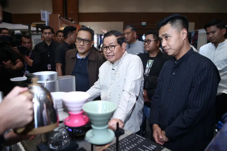 Biji kopi pilihan dan cangkir kopi espresso hangat yang diletakkan di atas meja kayu
