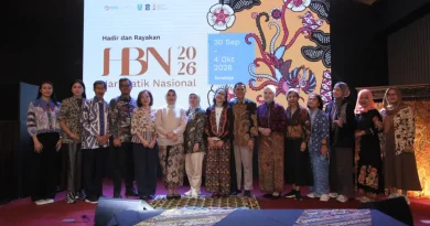 Perahu tradisional dihias motif batik Jawa Timur berlayar di sungai, merepresentasikan perpaduan budaya dan modernitas.