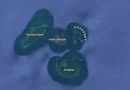 Ilustrasi batuan vulkanik hitam dan uap geotermal di tepi perairan