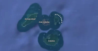 Ilustrasi batuan vulkanik hitam dan uap geotermal di tepi perairan
