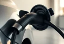Kabel pengisi daya mobil listrik terhubung ke soket kendaraan dengan pencahayaan lembut