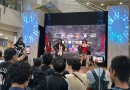 Ilustrasi mikrofon panggung dan penlight konser idol di atas meja kayu dengan pencahayaan dramatis
