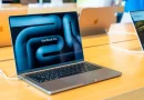 Ilustrasi laptop modern ramping dengan layar OLED cemerlang di atas meja kerja minimalis