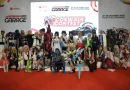 Detail komponen otomotif modern dan kunci pintar kendaraan di atas meja pameran bernuansa elegan